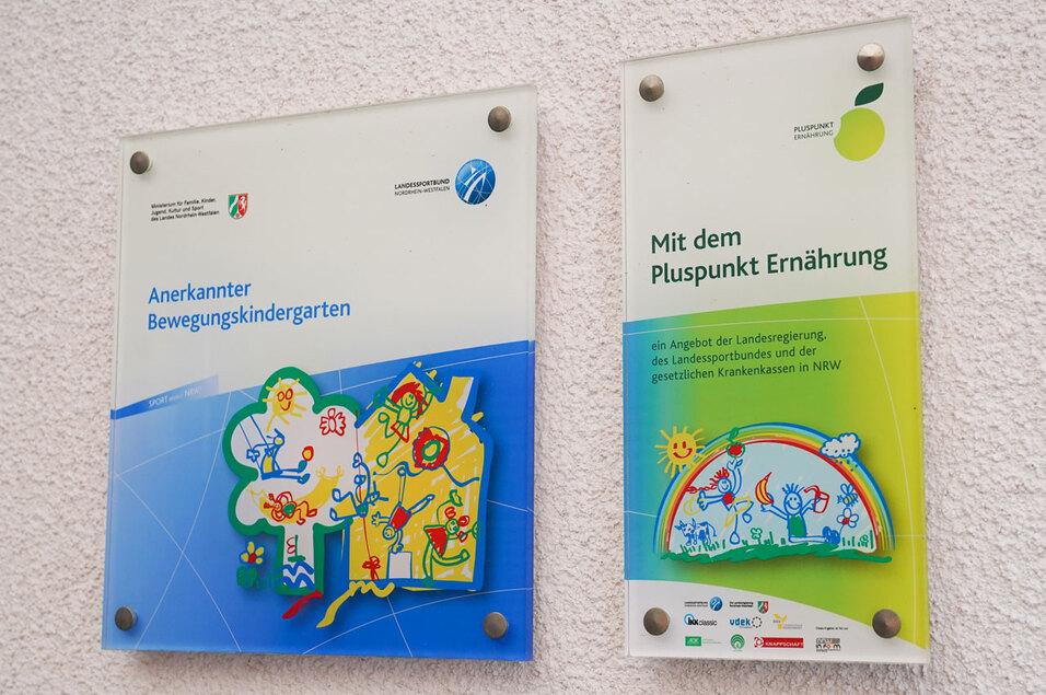 Zwei Informationsschilder: eines über den anerkannten Bewegungskindergarten, das andere über Pluspunkt Ernährung.