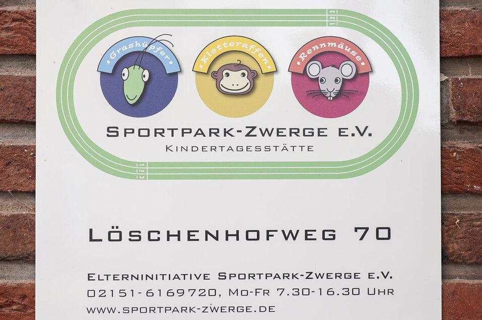 Schild der Kindertagesstätte „Sportpark-Zwerge e.V.“ mit bunten Tiermotiven und Kontaktdaten.